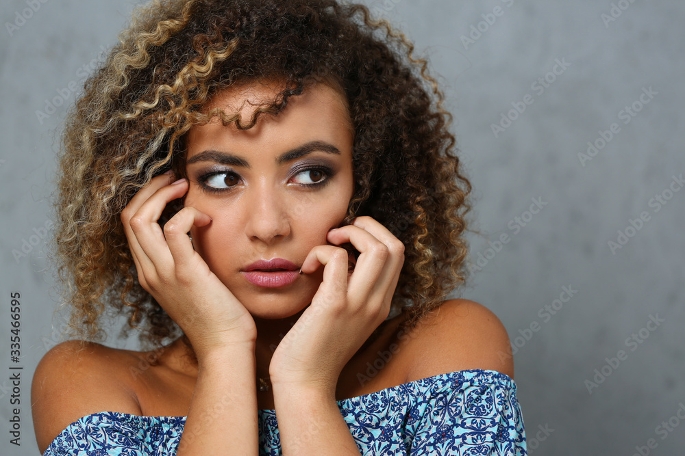 A beautiful black woman portrait. Tests the emotion of bewilderment of fear of terror confusion beauty fashion style curly hair with white locks eye view of the camera