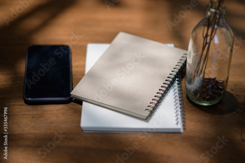 Notebook and pen placed on a wooden table.working at home concept .
