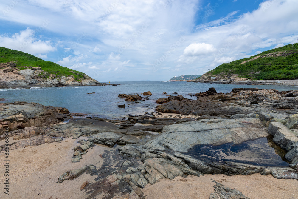 view of the coast of the sea on a rocky beach during sunny weather