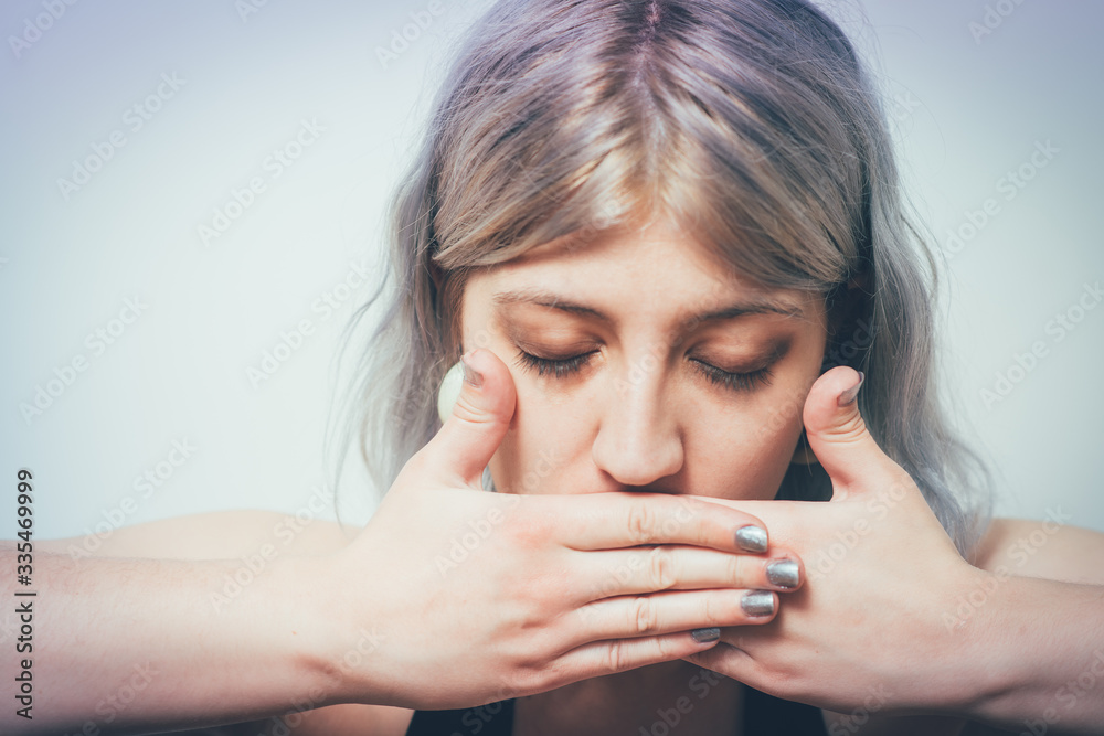 Successful stylish girl covers her mouth with her hands, isolated in the studio Successful stylish girl covers her mouth with her hands, isolated in the studio
