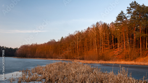 Konstfotografi Zachód słońca nar zalewem rzeki przebiegającej przez las