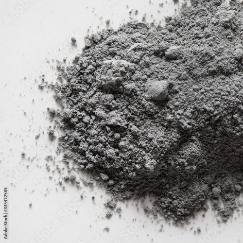 Top view of natural colored gray pigment powder close up. Matt grey eyeshadow or powder pigment on a white background. Cosmetic ingredients. A pile of a dust. Close-up