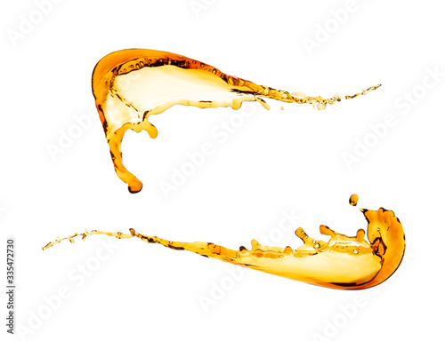 Two splashes of clear yellow liquid isolated on white background. File contains a path to isolation.