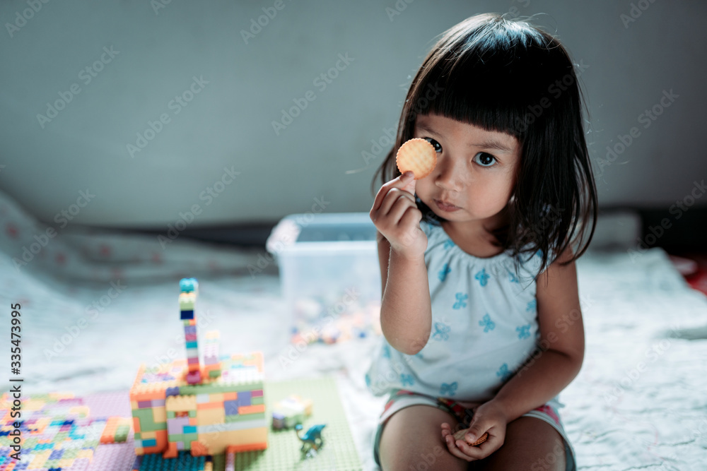 Kid enjoy eating biscuits and relax stay at home - obrazy, fototapety, plakaty 