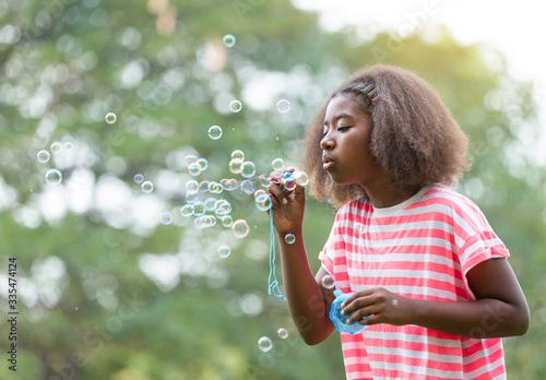 African American girl  playing with soap bubbles in the park