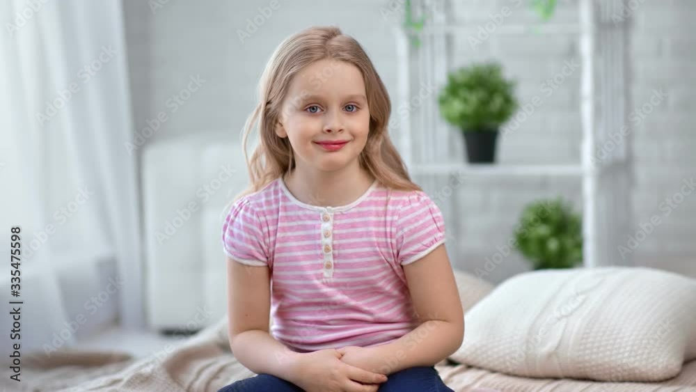 Portrait cute baby girl with blonde hair smiling sitting on bed at cozy home. 4k Dragon RED camera Portrait cute baby girl with blonde hair smiling sitting on bed at cozy home. 4k Dragon RED camera