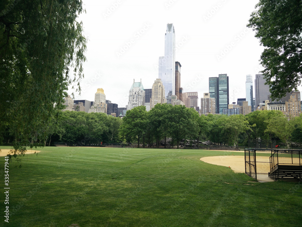 A sports field in New York's Central Park. A playground without people in Manhattan against a backdrop of skyscrapers.