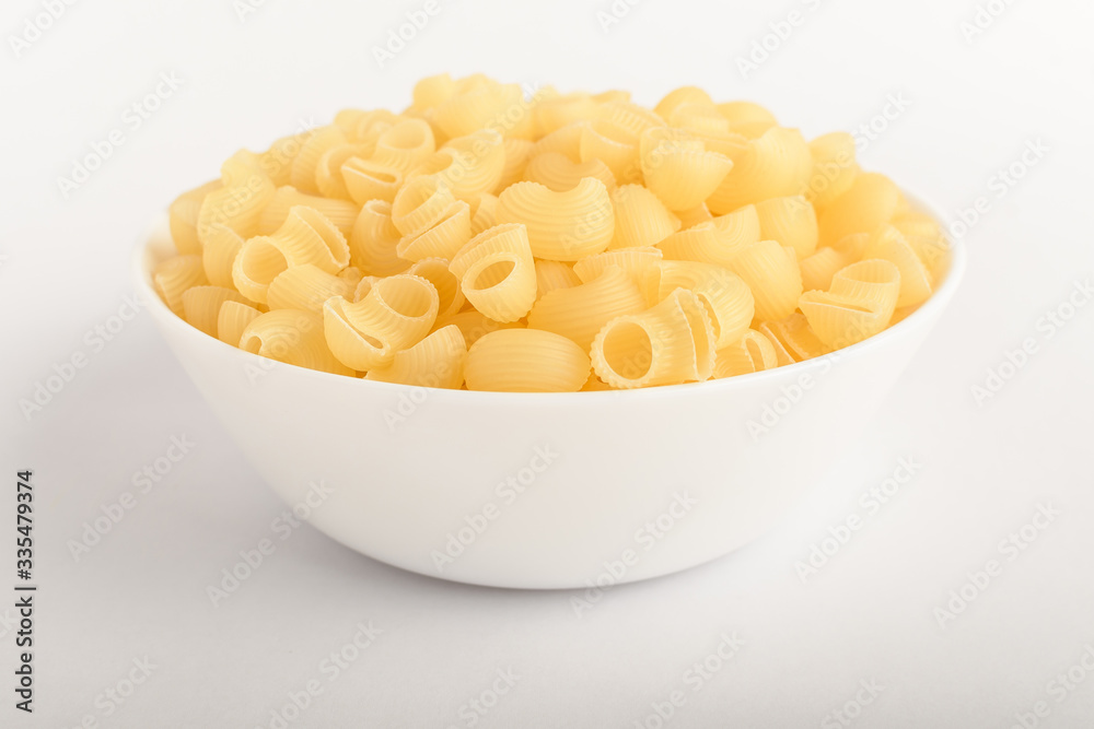 Dried cornetti rigati Italian pasta in a round bowl ready to be cooked, isolated on a white table, top view or flat lay of healthy food
Dried cornetti rigati Italian pasta in a round bowl ready to be cooked, isolated on a white table, top view or flat lay of healthy food