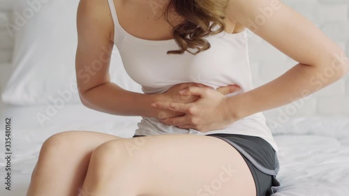 woman have bladder pain and stomach ache sitting on bed in bedroom after wake up feeling so sick and painful,Healthcare concept