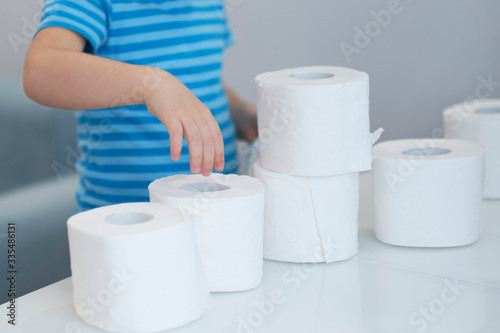 Active boy playing with toilet paper in retro filter,kid boy looking through toilet roll,Child hugs a bunch of toilet paper, Children health care concept