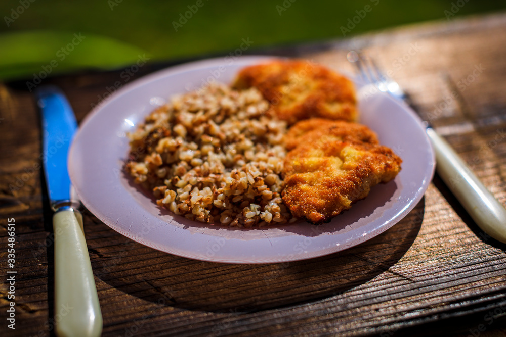 Chicken schnitzel with buckwheat on plate over wooden background. Top view, flat lay. Chicken schnitzel with buckwheat on plate over wooden background. Top view, flat lay.