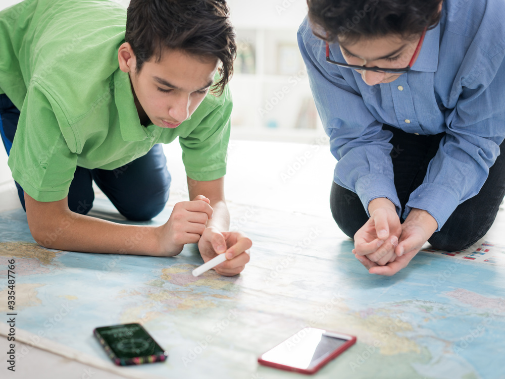 Two boys searching on world map Two boys searching on world map
