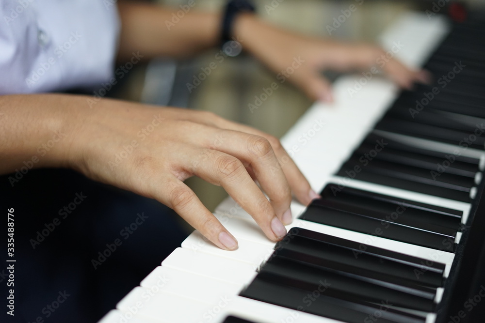 Fototapeta premium close up of the hands of girl on the keyboard of the piano