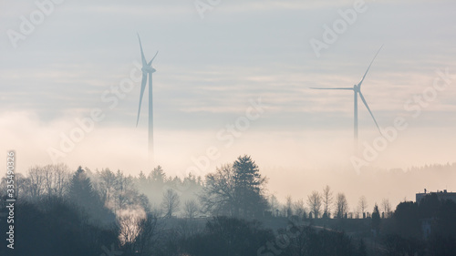 Starnberg, Bavaria / Germany - Mar 31 2020: Silhouette of two wind turbines at dusk. Located close to Lake Starnberg (Starnberger See). Producing energy for bavarian households. Panorama format.