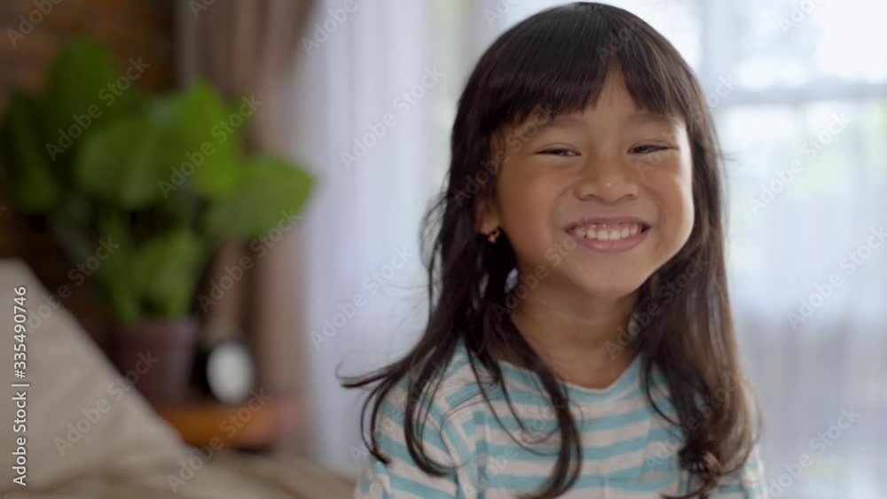 happy excited asian young girl kid sitting on the bed happy excited asian young girl kid sitting on the bed