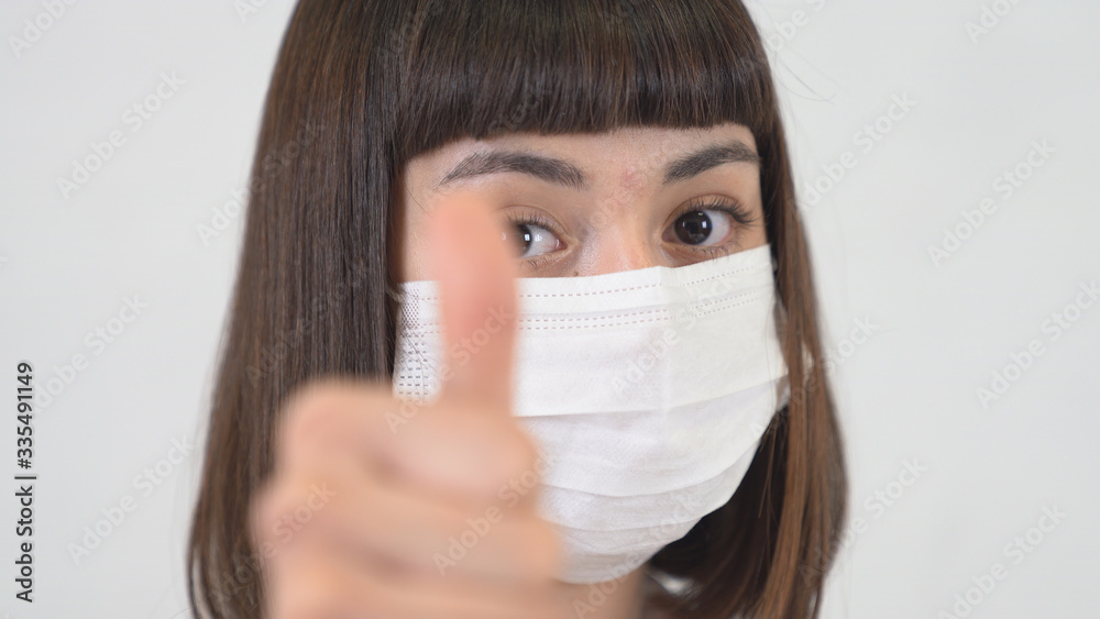 A asian young girl that infected by coronavirus makes positive sign as treatment. A asian young girl that infected by coronavirus makes positive sign as treatment.