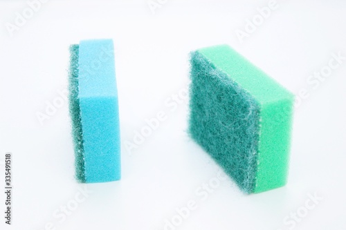 Multi-colored dishwashing sponges are placed on a white background