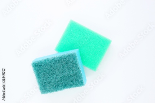 Multi-colored dishwashing sponges are placed on a white background