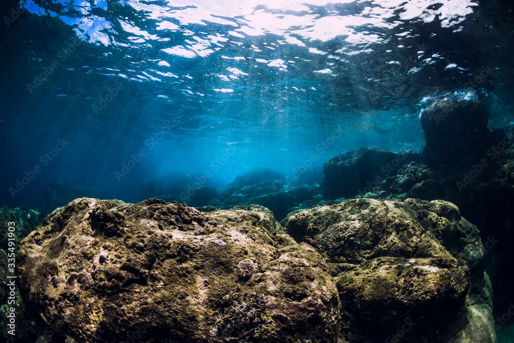 Underwater scene with stones and sunlight in ocean