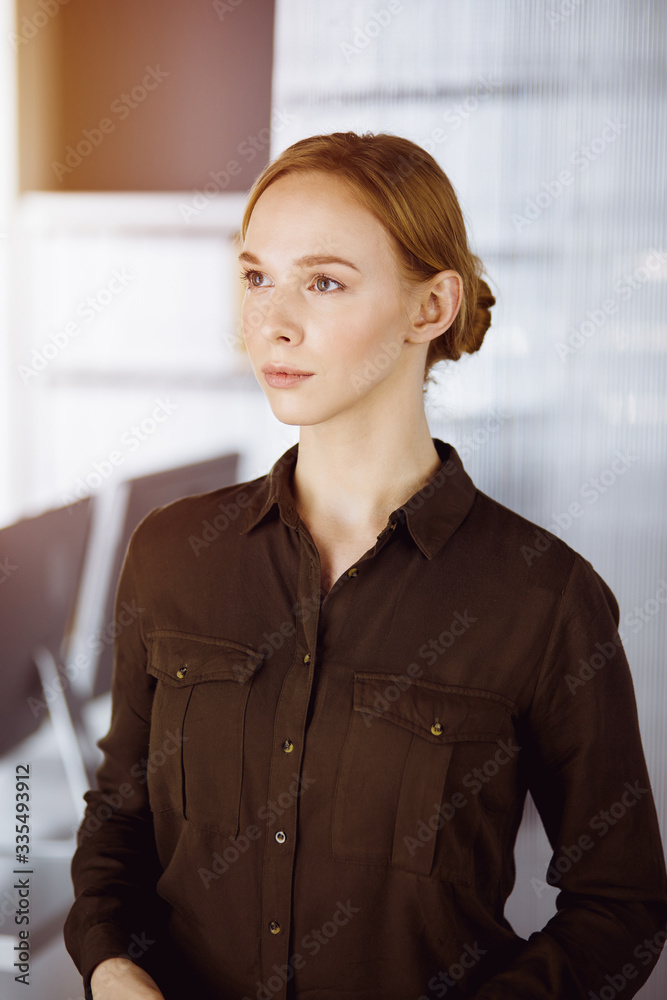 Friendly adult casual dressed business woman standing straight. Concept of a business headshot or portrait in office Friendly adult casual dressed business woman standing straight. Concept of a business headshot or portrait in office