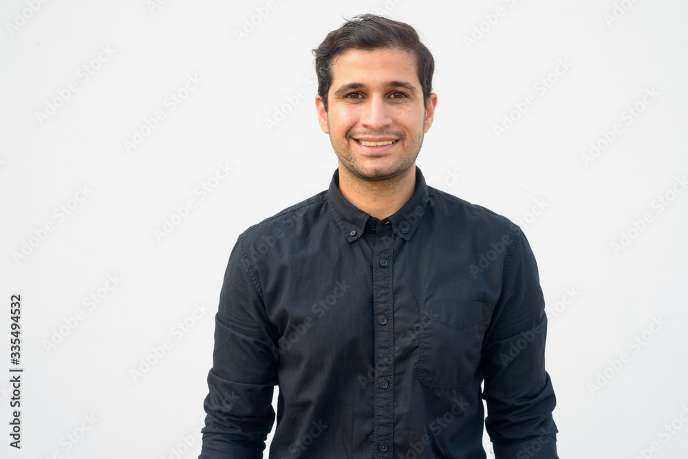 Portrait of happy young handsome Persian businessman smiling Portrait of happy young handsome Persian businessman smiling