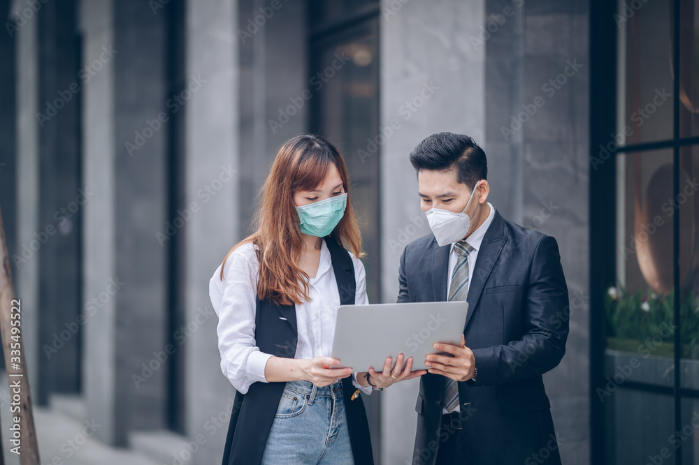 Corona Virus but working business - Asian business team discussion on laptop and wear mask protect pollution Corona Virus but working business - Asian business team discussion on laptop and wear mask protect pollution