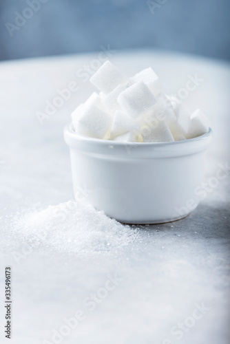 Sugar cubes and grain of sugar