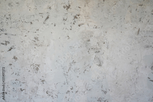 Light grey cement wall with random grunge textures on surface.  Renovation, decoration ideas for background and building objects.