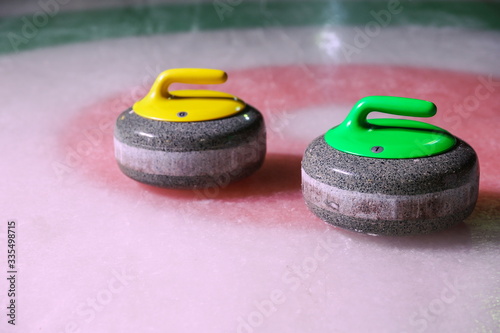 curling stones on ice near the home colorful background