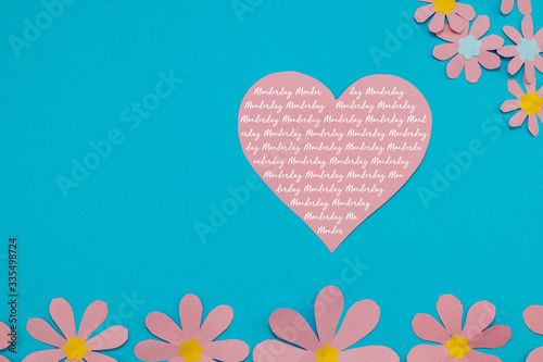 Dutch text Moederdag, Mother's Day with pink paper flowers on a blue background. Room for copy. 