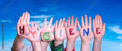 Kids Hands Holding Colorful English Word Hygiene. Blue Sky As Background photo