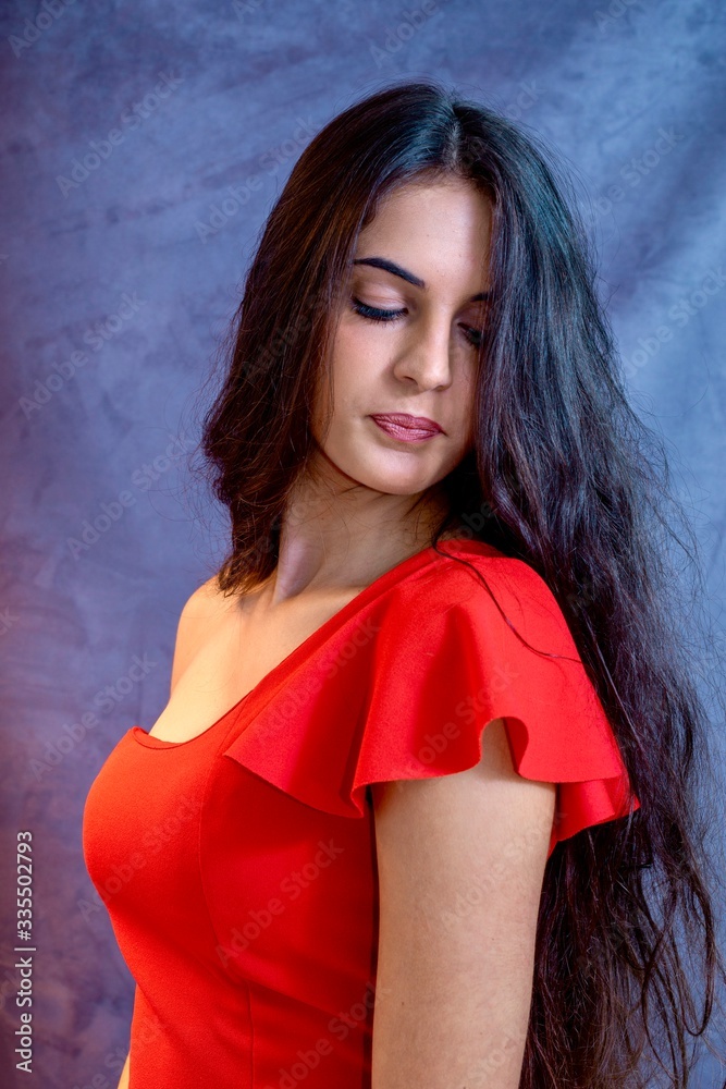 Fototapeta premium black hair woman portrait with brown eyes on a gray background , Caucasian ethnic group is looking into the camera with a serious expression on her face. White girl with long black hair and brown eye