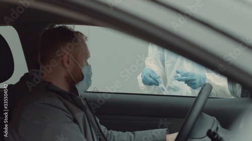 Patient is being tested in his vehicle on a drive-through coronavirus COVID-19 testing location. Pandemic, infection © supamotion