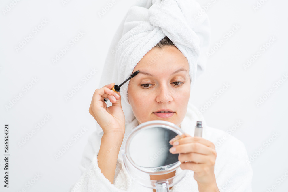 Beauty woman holds mirror and applies makeup at home Beauty woman holds mirror and applies makeup at home