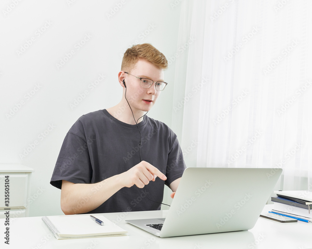 Distance learning or working. Quarantine, self-isolation, social phobia. Young boy speaking on online training, Distance learning or working. Quarantine, self-isolation, social phobia. Young boy speaking on online training,