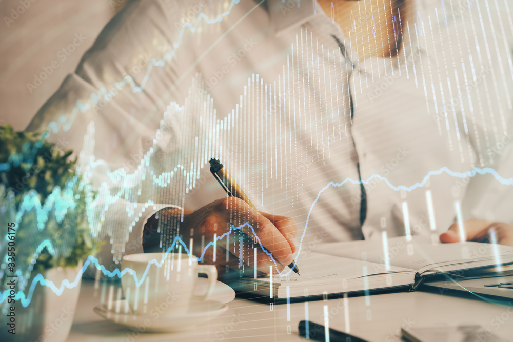 Fototapeta premium Double exposure of man's hands writing notes of stock market with forex chart.