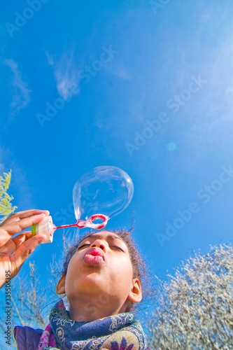 girl creates soap bubbles in the blue sky