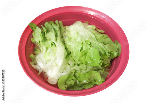 Vegetable soak in water in a red plastic bowl