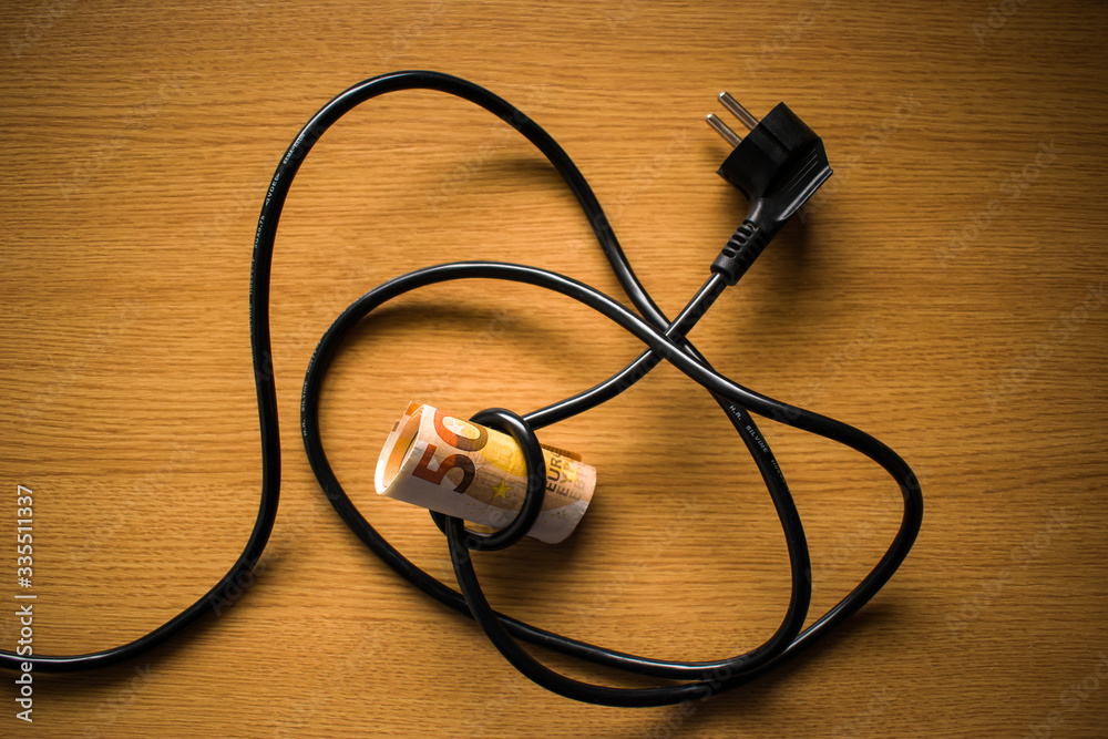 Electric power plug and euro banknotes. Cost, expenses electricity concept Electric power plug and euro banknotes. Cost, expenses electricity concept