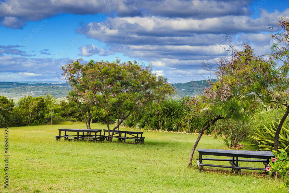 Fototapeta A picnic area on the top of a green, tropical hillside
