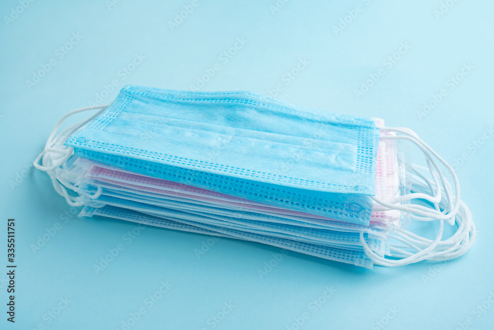 Disposable medical mask on light blue background Disposable medical mask on light blue background