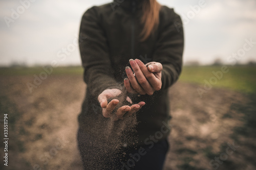 Photos Female hands pouring a black soil in the field