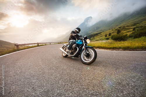 Fototapeta Naklejka Na Ścianę i Meble -  Motorcycle driver riding in Dolomite pass, Italy, south Europe.