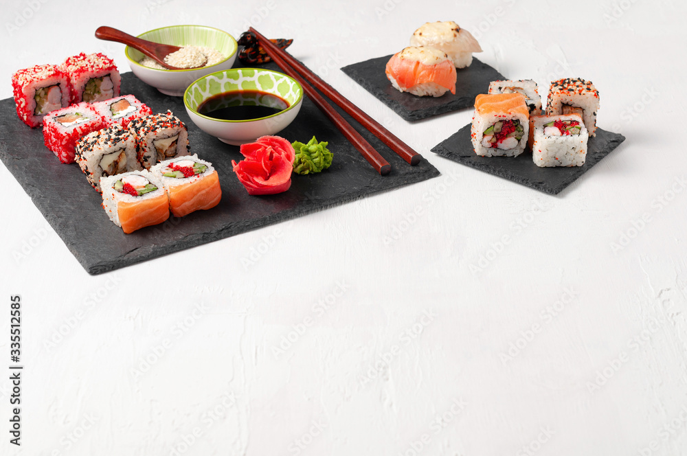 Japanese cuisine. Assorted sushi maki gunkan roll on white table