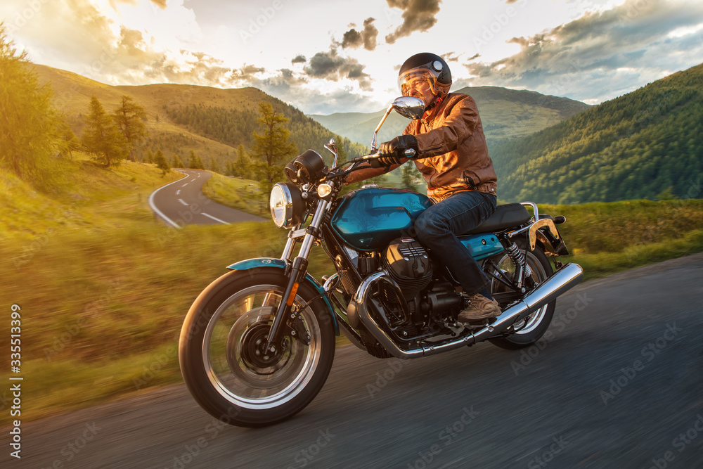 Motorcycle driver riding in Alpine highway, Nockalmstrasse, Austria, central Europe. Motorcycle driver riding in Alpine highway, Nockalmstrasse, Austria, central Europe.