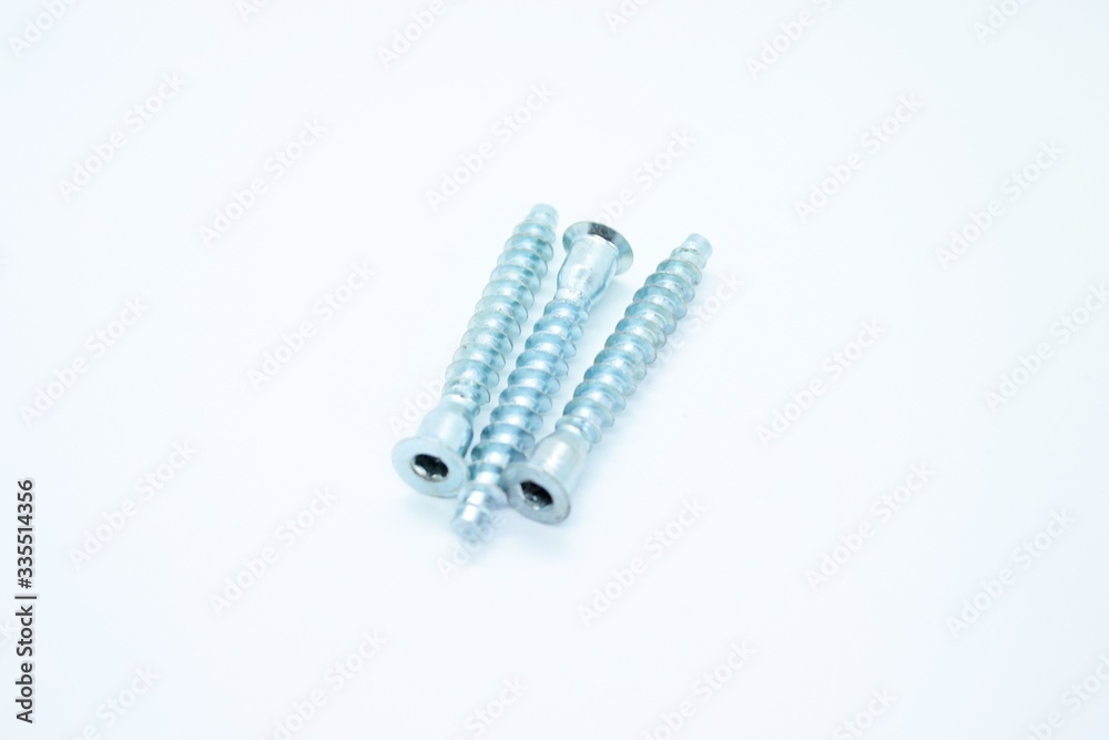 White metal screws located on a white background White metal screws located on a white background