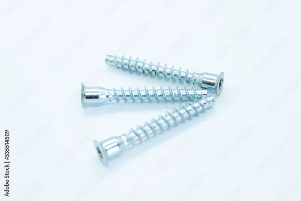 White metal screws located on a white background White metal screws located on a white background