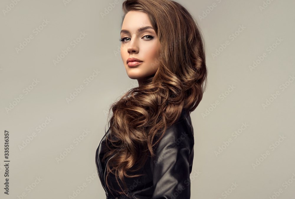 Beautiful stylish woman wearing  black leather jacket. Fashionable and self-confident girl with long curly hair. Clothing, style and fashion - obrazy, fototapety, plakaty 