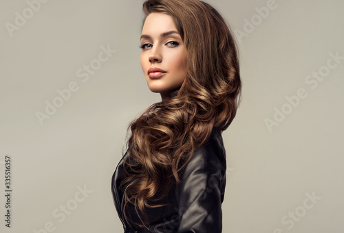 Beautiful stylish woman wearing  black leather jacket. Fashionable and self-confident girl with long curly hair. Clothing, style and fashion