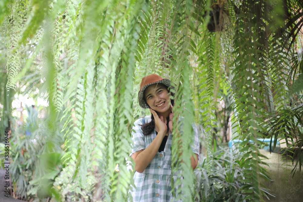 Smiling woman and nephrolepis sp fern leaves in a garden, Thailand Smiling woman and nephrolepis sp fern leaves in a garden, Thailand